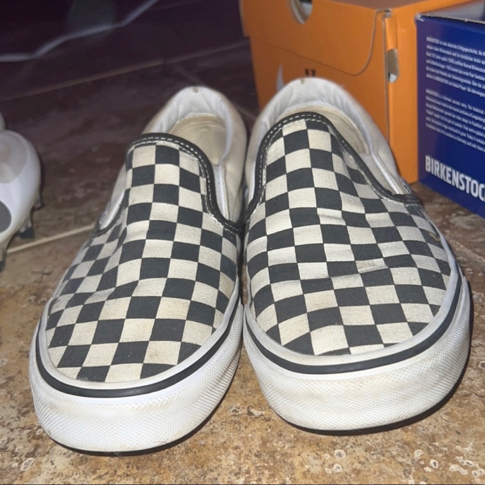 black and cream colored slip on vans